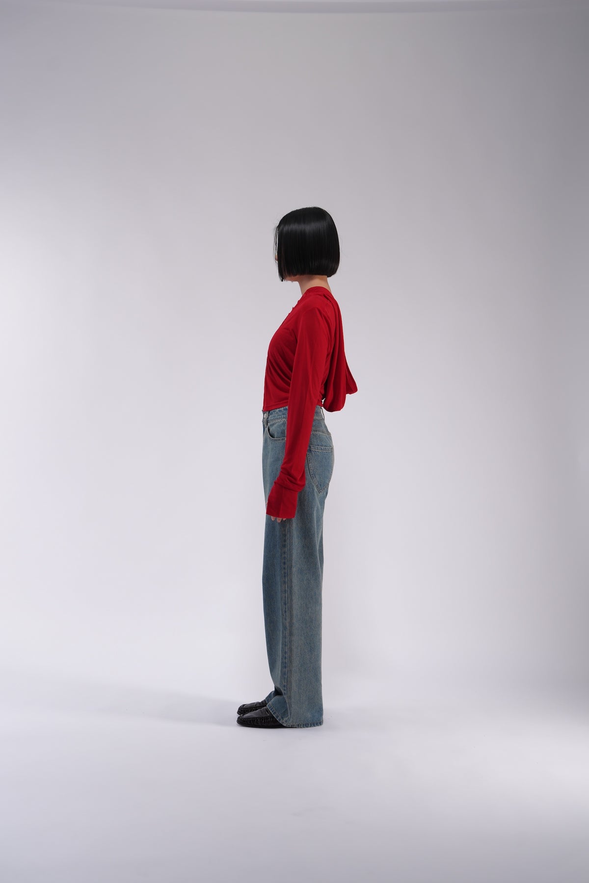 YOSEN ウォッシュドストレートデニムパンツ ブルー｜赤いカーディガンを合わせた横向きの着用イメージ